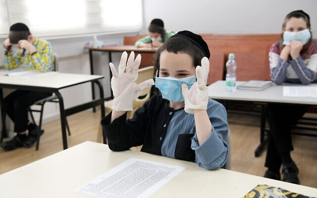 Des écoliers ultra-orthodoxes de l'école Bnei Moshe Kretchnif portant des masques faciaux dans leur école de la ville de Rehovot, le 24 mai 2020. (Yossi Zeliger/Flash90)