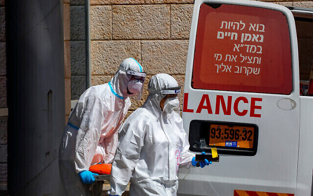 Employés du Magen David Adom portant des équipements de protection après avoir évacué un homme soupçonné d’être porteur du Coronavirus au centre médical Hadassah Ein Kerem à Jérusalem, le 20 juillet 2020. (Autorisation : Olivier Fitoussi / Flash90) Employés du Magen David Adom portant des équipements de protection après avoir évacué un homme soupçonné d’être porteur du Coronavirus au centre médical Hadassah Ein Kerem à Jérusalem, le 20 juillet 2020. (Autorisation : Olivier Fitoussi / Flash90)