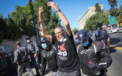 La police éloigne Carmi Gillon, un ancien chef du Shin Bet, d'un campement de protestation devant la résidence officielle du Premier ministre, le 20a août 2020. (Crédit : Olivier Fitoussi/Flash90)