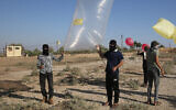 Des Palestiniens se préparent à lancer des ballons incendiaires ou transportant des dispositifs explosifs vers Israël, le 21 août 2020 (Crédit : Fadi Fahd/Flash90)