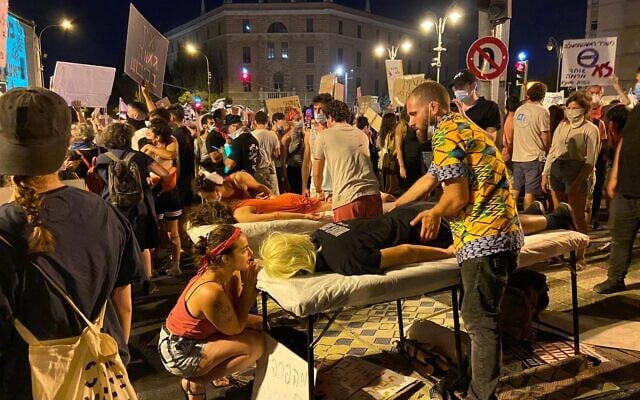 Des tables de massages dressées par les activistes lors d'une manifestation aux abords de la résidence du Premier ministre Benjamin Netanyahu à Jérusalem, le 1er août 2020. (Crédit : Anat Peled/Times of Israel)