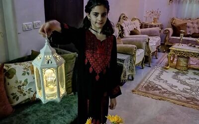 Un membre de la famille Abu Sbeih de Jérusalem-Est honore une tradition du Ramadan de brandir une lanterne dans le salon, avant la démolition de la maison familiale. (Iyad Abu Sbeih)
