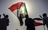 Des manifestants soudanais défilent avec des drapeaux nationaux alors qu'ils se rassemblent lors d'une manifestation pour demander la création d'organes civils pour mener la transition vers la démocratie, devant le quartier général de l'armée dans la capitale soudanaise de Khartoum, le 13 avril 2019. (AP Photo)