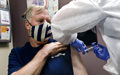 Une infirmière procède à une injection, dans la plus grand étude du monde sur un possible vaccin du COVID-19, développé par le National Institutes of Health and Moderna Inc., le 27 juillet 2020 à Binghamton, NY. (AP Photo/Hans Pennink)
