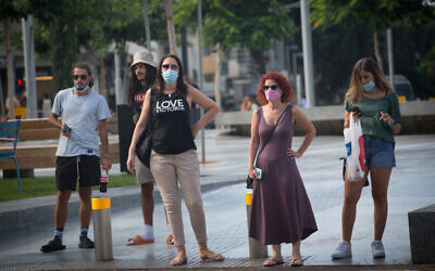 Des israéliens portent des masque de protection à Tel Aviv, el 4 août 2020. (Photo par Miriam Alster/Flash90)