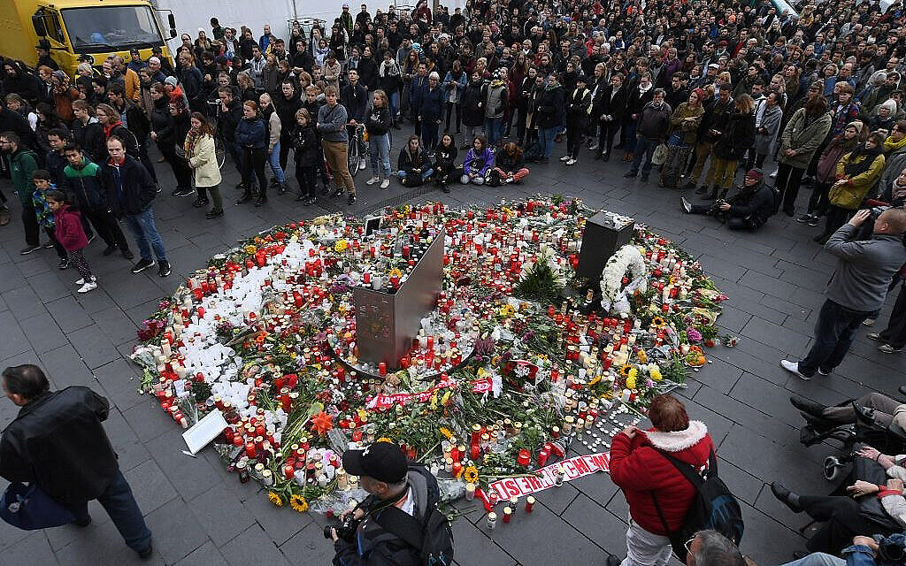 Des Allemands se regroupent autour d'un mémorial à la mémoire des victimes d'une fusillade meurtrière contre un restaurant turc après une tentative d'attentat contre une synagogue à Halle, en Allemagne, le 11 octobre 2019 (Crédit : Hendrik Schmidt / dpa / AFP)