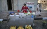 Un vendeur palestinien masqué dispose des produits dans une rue de la ville de Gaza, le 3 septembre 2020, alors qu'une pandémie de coronavirus COVID-19 impose un confinement. (MOHAMMED ABED / AFP)