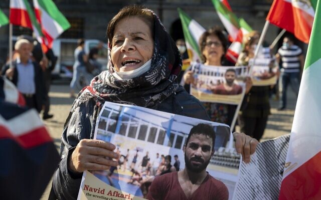 Une femme tient un portrait du lutteur iranien Navid Afkari lors d'une manifestation sur la place du Dam à Amsterdam, aux Pays-Bas, le 13 septembre 2020, contre son exécution dans la ville de Shiraz, dans le sud de l'Iran, et contre le gouvernement iranien. (Evert Elzinga / ANP / AFP) Une femme tient un portrait du lutteur iranien Navid Afkari lors d'une manifestation sur la place du Dam à Amsterdam, aux Pays-Bas, le 13 septembre 2020, contre son exécution dans la ville de Shiraz, dans le sud de l'Iran, et contre le gouvernement iranien. (Evert Elzinga / ANP / AFP)
