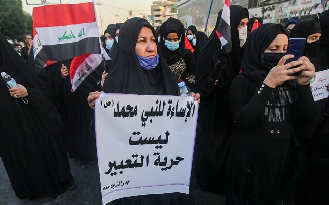 Une femme portant un masque contre le coronavirus brandit une affiche disant en arabe : "Insulter le prophète Mahomet n'est pas de la liberté d'expression" lors d'une manifestation devant l'ambassade de France en Irak, à Bagdad, le 17 septembre 2020. (Crédit : AHMAD AL-RUBAYE / AFP) Une femme portant un masque contre le coronavirus brandit une affiche disant en arabe : "Insulter le prophète Mahomet n'est pas de la liberté d'expression" lors d'une manifestation devant l'ambassade de France en Irak, à Bagdad, le 17 septembre 2020. (Crédit : AHMAD AL-RUBAYE / AFP)