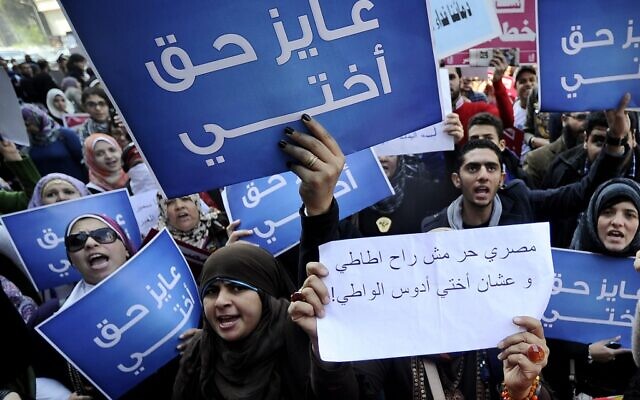 Dans cette photo d'archive prise le 27 décembre 2011, des femmes égyptiennes tiennent des pancartes sur lesquelles on peut lire en arabe « Je veux les droits pour ma sœur » alors qu'elles protestent contre les violations du conseil militaire et les tests de virginité sur les femmes, devant le tribunal du Conseil d'État au Caire. (Filippo MONTEFORTE / AFP)