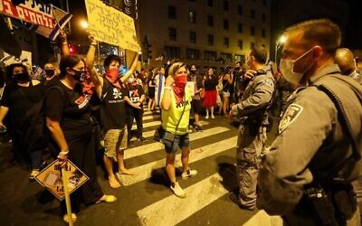 Des manifestants israéliens au cours d'une manifestation, en plein confinement, devant la résidence du Premier ministre Benjamin Netanyahu à Jérusalem, réclamant sa démission, le 26 septembre 2020 (Crédit : EMMANUEL DUNAND / AFP)