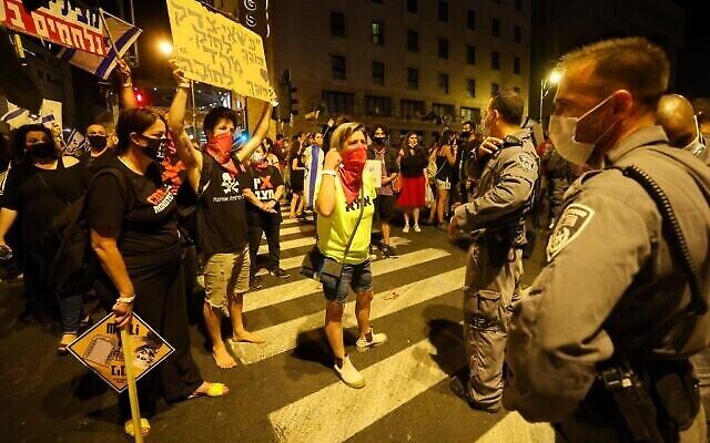 Des manifestants israéliens au cours d'une manifestation, en plein confinement, devant la résidence du Premier ministre Benjamin Netanyahu à Jérusalem, réclamant sa démission, le 26 septembre 2020 (Crédit : EMMANUEL DUNAND / AFP)
