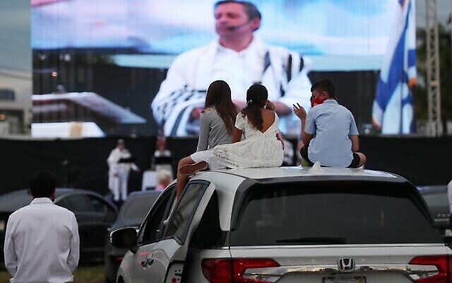 NORTH MIAMI, FLORIDA - SEPTEMBER Le rabbin Jonathan Berkun à l'écran alors qu'il assure un office de Yom Kippour, auquel les  fidèles assisent depuis leurs voitures en pleine pandémie de coronavirus,  dans un cinéma en plein air de Dezerland Park, à North Miami, en Floride, le 28 septembre 2020 (Crédit :   Joe Raedle/Getty Images/AFP