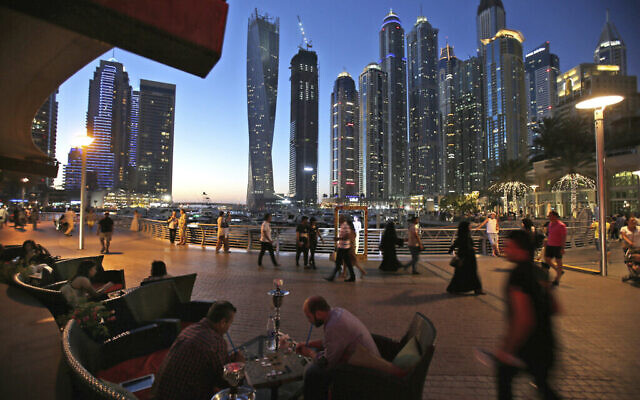 Deux hommes jouent au backgammon tout en fumant une shisha, pipe à eau, dans un restaurant surplombant le canal et le quartier de la marina de Dubaï, à Dubaï, aux Émirats arabes unis, le 1er mai 2015. (AP Photo/Kamran Jebreili, Dossier)