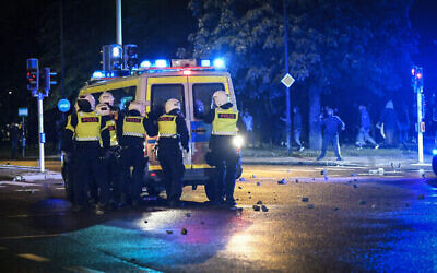 Des manifestants lancent des pierres sur la police lors d'échauffourées dans le quartier de Rosengard à Malmö, en Suède, 28 août 2020. (Crédit : TT News Agency via AP)