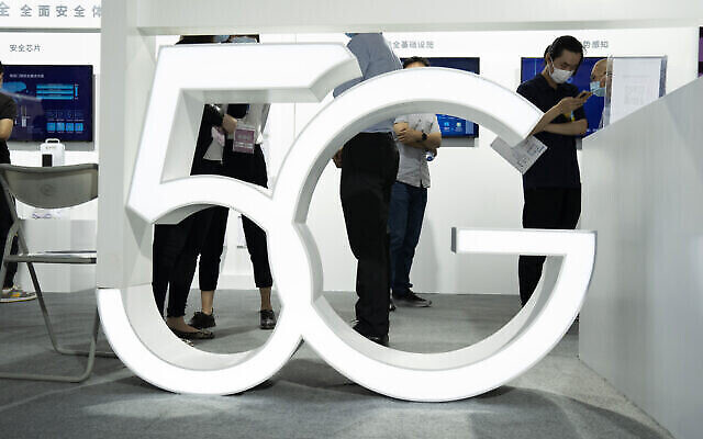 Des visiteurs portant des masques contre le coronavirus passent devant un sigle 5G géant à la China Beijing International High Tech Expo, à Pékin, le 17 septembre 2020. (Crédit : AP Photo/Ng Han Guan) Des visiteurs portant des masques contre le coronavirus passent devant un sigle 5G géant à la China Beijing International High Tech Expo, à Pékin, le 17 septembre 2020. (Crédit : AP Photo/Ng Han Guan)