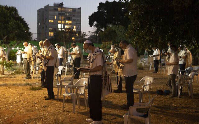 Des Israéliens prient aux abords d'une synagogue pour Yom Kippour, la journée la plus sainte de l'année juive, à Tel Aviv, le 27 septembre 2020 (Crédit : AP Photo/Sebastian Scheiner)