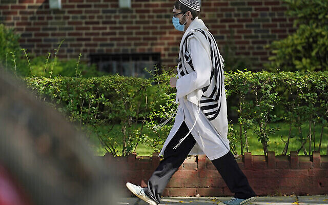 Un fidèle marche dans le quartier Midwood de Brooklyn, à New York, le 28 septembre 2020 (Crédit : AP Photo/Kathy Willens)
