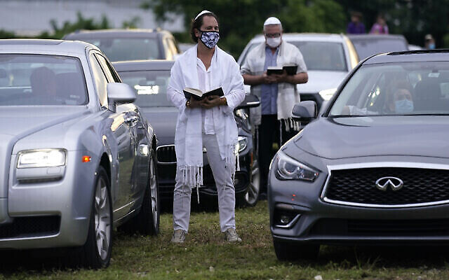 Alexis Weinberg à l'extérieur de sa voiture pendant un service de Yom Kippour organisé par le centre juif  Aventura Turnberry  pendant la pandémie de coronavirus, dans un cinéma en plein air de Dezerland Park, à North Miami, en Floride, le 28 septembre 2020 (Crédit : AP Photo/Lynne Sladky)