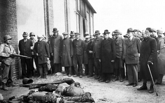 Les Bürgermeister des villes voisines qui entouraient le campsde concentration  de Gardelegen, en Allemagne, constatent les atrocités commises dans une cour de ferme aux abords de la ville, une photo prise par des soldats de la. Ninth Army  américaine, le 18 avril 1945 (Crédit : AP Photo)