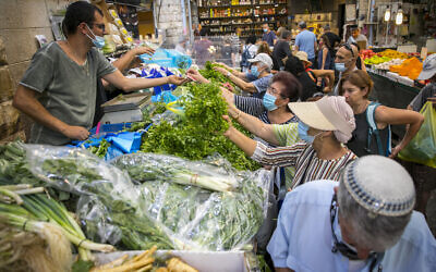 Des Israéliens, portant des masques faciaux par crainte du coronavirus, font leurs courses au marché Mahane Yehuda à Jérusalem, le 14 septembre 2020. (Olivier Fitoussi/Flash90)