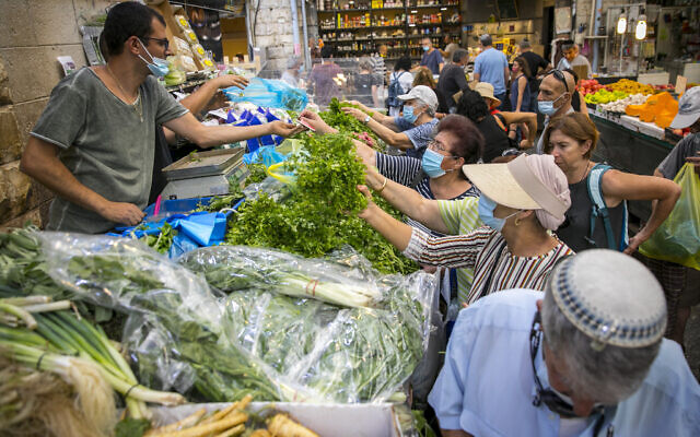 Des Israéliens, portant des masques faciaux par crainte du coronavirus, font leurs courses au marché Mahane Yehuda à Jérusalem, le 14 septembre 2020. (Olivier Fitoussi/Flash90) Des Israéliens, portant des masques faciaux par crainte du coronavirus, font leurs courses au marché Mahane Yehuda à Jérusalem, le 14 septembre 2020. (Olivier Fitoussi/Flash90)