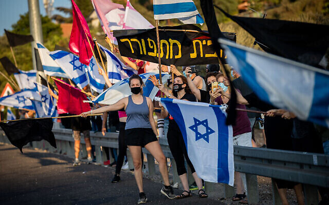 Des manifestants anti-Netanyahu sur la Route 1, à Jérusalem, pendant un confinement national, le 26 septembre 2020 (Crédit :Nati Shohat/Flash90)