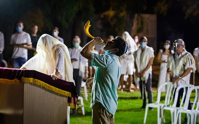 Un homme souffle dans le Shofar à la fin de Yom Kippour au Moshav Haniel, en Israël, le 28 septembre 2020 (Crédit : Chen Leopold/Flash90)