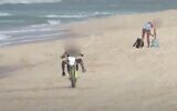 Un homme considéré comme un danger pour les baigneurs est vu en train de conduire une moto dans la ville d'Ashdod, dans le sud du pays, le 11 septembre 2020. (Capture d'écran : YouTube)