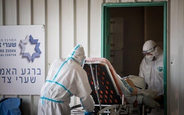 Des travailleurs de Magen David Adom portant des vêtements de protection à l'extérieur de l'unité des coronavirus de l'hôpital Shaare Zedek à Jérusalem, le 10 septembre 2020. (Yonatan Sindel/Flash90) Des travailleurs de Magen David Adom portant des vêtements de protection à l'extérieur de l'unité des coronavirus de l'hôpital Shaare Zedek à Jérusalem, le 10 septembre 2020. (Yonatan Sindel/Flash90)