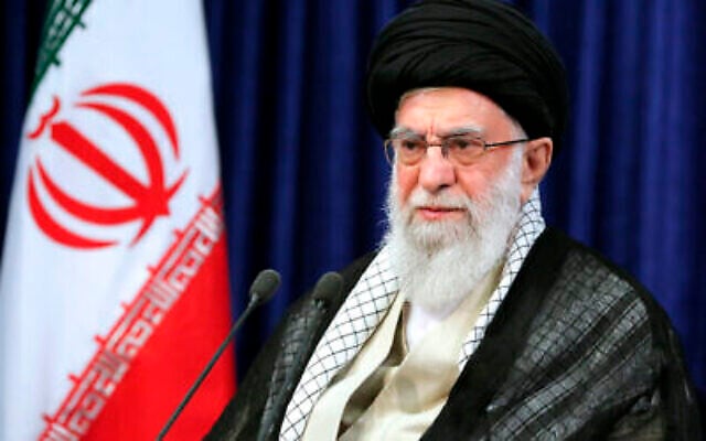 Le guide suprême, l'ayatollah Ali Khamenei, s'exprime à l'occasion de l'anniversaire de la mort du fondateur de la République islamique, l'ayatollah Ruhollah Khomeini, représenté sur l'affiche en haut au centre, dans son mausolée à Téhéran, en Iran, le 4 juin 2022. (Crédit : Bureau du Guide suprême iranien/AP) Le guide suprême, l'ayatollah Ali Khamenei, s'exprime à l'occasion de l'anniversaire de la mort du fondateur de la République islamique, l'ayatollah Ruhollah Khomeini, représenté sur l'affiche en haut au centre, dans son mausolée à Téhéran, en Iran, le 4 juin 2022. (Crédit : Bureau du Guide suprême iranien/AP)