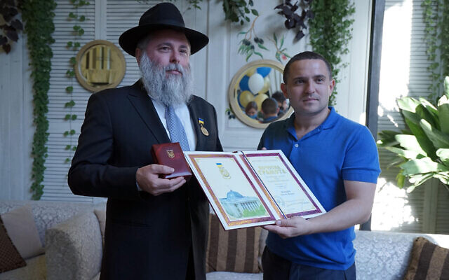 Le rabbin Yonatan Markovitch, à gauche, brandit une médaille et un certificat décernés au Parlement ukrainien à Kiev, le 7 septembre 2020. (Avec l'aimable autorisation de Markovitch via JTA)