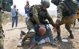 Des soldats israéliens arrêtant le Palestinien Khairi Hanoun lors d'une manifestation contre l'expansion de la présence juive, dans le village de Shufah en Cisjordanie, le 1ᵉʳ septembre 2020. (Crédit : Majdi Mohammed/AP)