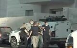 Walid Mansour, (au centre), menotté, reconstitue son attaque au couteau présumée d'un Israélien sur un chantier de construction à Rosh Haayin. (Crédit : Douzième chaîne)