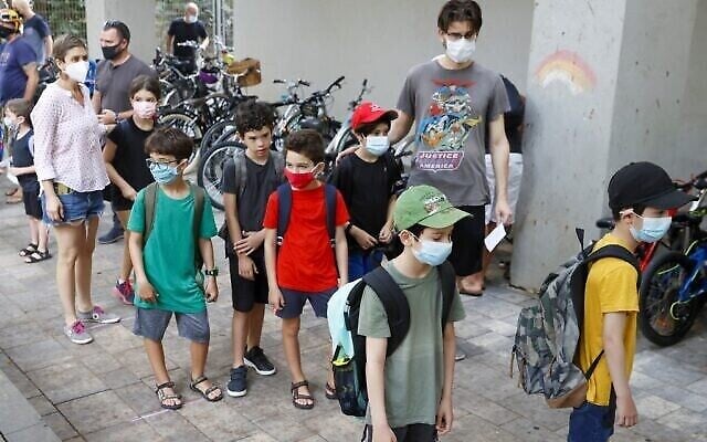 Des parents israéliens accompagnent leurs enfants pour le premier jour d'école, lors de la pandémie de coronavirus, à Tel Aviv le 1er septembre 2020. (JACK GUEZ / AFP)