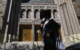 Un Juif hassidique devant une synagogue fermée à Borough Park à Brooklyn, l'un des cinq arrondissements de New York, le 9 octobre 2020. (Crédit : Angela Weiss / AFP)