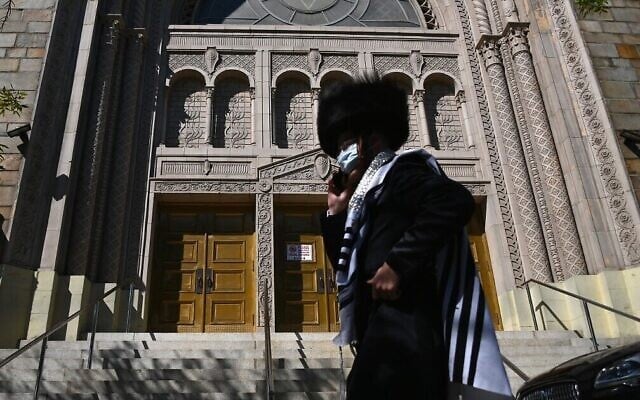 Un Juif hassidique devant une synagogue fermée à Borough Park à Brooklyn, l'un des cinq arrondissements de New York, le 9 octobre 2020. (Crédit : Angela Weiss / AFP) Un Juif hassidique devant une synagogue fermée à Borough Park à Brooklyn, l'un des cinq arrondissements de New York, le 9 octobre 2020. (Crédit : Angela Weiss / AFP)