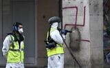 Des employés municipaux nettoient des croix gammées sur les arcades de la rue de Rivoli, à Paris, le 11 octobre 2020. (Crédit : STEPHANE DE SAKUTIN / AFP)