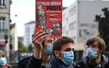 Un homme tient une édition du magazine Charlie Hebdo lors d'une manifestation à Rennes le 17 octobre 2020, un jour après la décapitation d'un enseignant à Conflans-Sainte-Honorine, à 30 km au nord-ouest de Paris, lors d'une attaque terroriste islamiste. (Damien MEYER / AFP)