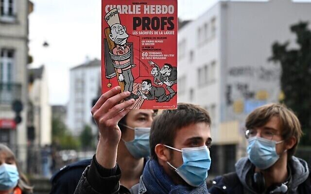 Un homme tient une édition du magazine Charlie Hebdo lors d'une manifestation à Rennes le 17 octobre 2020, un jour après la décapitation d'un enseignant à Conflans-Sainte-Honorine, à 30 km au nord-ouest de Paris, lors d'une attaque terroriste islamiste. (Damien MEYER / AFP) Un homme tient une édition du magazine Charlie Hebdo lors d'une manifestation à Rennes le 17 octobre 2020, un jour après la décapitation d'un enseignant à Conflans-Sainte-Honorine, à 30 km au nord-ouest de Paris, lors d'une attaque terroriste islamiste. (Damien MEYER / AFP)