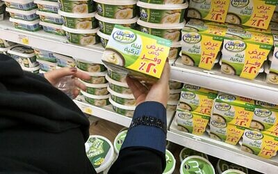 Une femme tient une boite de labneh turc dans un supermarché de Ryad, en Arabie saoudite, le 18 octobre 2020.(Crédit : FAYEZ NURELDINE / AFP)
