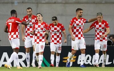 Les joueurs de Hapoel Beer Sheva célèbrent leur but d'ouverture en Ligue Europa, marqué par Jonathan Agudelo, lors du match contre le Slavia Prague (République tchèque) au stade Hamoshava de la ville israélienne de Petah Tikva, le 22 octobre 2020. (Crédit : JACK GUEZ / AFP)