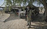 Un soldat israélien, masqué en raison de la pandémie de coronavirus COVID-19, monte la garde à côté d'un avant-poste et de véhicules militaires de transport à roues polyvalents (Humvee) lors de l'exercice militaire "Deadly Arrow" dans le nord d'Israël, le 27 octobre 2020. (Crédit : Jalaa Marey/AFP)
