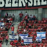 Les supporters de l'Hapoël Beer-Sheva agitent des drapeaux israéliens avant le match de football de barrage entre le Celtic et Hapoël Beer-Sheva, au Turner Stadium dans la ville de Beer-Sheva, au sud d'Israël, le 23 août 2016. (Crédit : Gil Cohen-Magen/AFP)