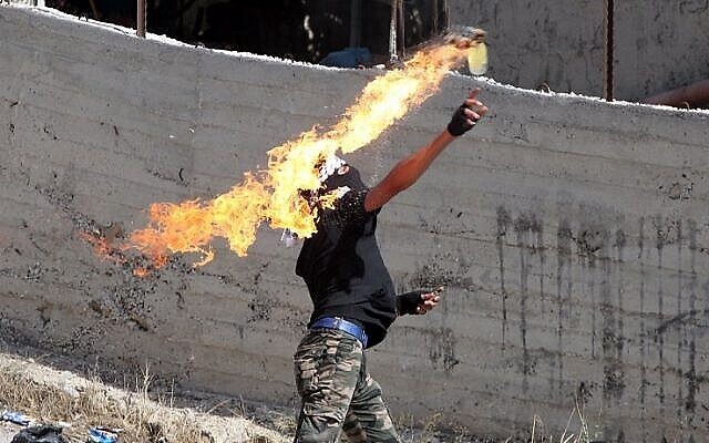 Illustration : un Palestinien lance un cocktail Molotov contre les forces de sécurité israéliennes lors d'affrontements près de la ville d'Hébron en Cisjordanie, le 11 octobre 2015. (AFP / Hazem Bader) Illustration : un Palestinien lance un cocktail Molotov contre les forces de sécurité israéliennes lors d'affrontements près de la ville d'Hébron en Cisjordanie, le 11 octobre 2015. (AFP / Hazem Bader)