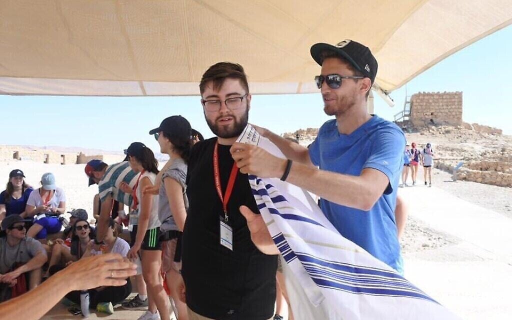Justin Christopher Tobin, revêtant un tallit ici lors d'un séjour Birthright, a été interrogé par des agents El Al au sujet de son deuxième prénom lors de son voyage pour Israël. (Autorisation : Tobin/ via JTA)