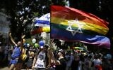 Des Israéliens et des touristes brandissent des drapeaux à la Gay Pride de Tel Aviv, le 8 juin 2018. (Crédit : AP/Sebastian Scheiner)