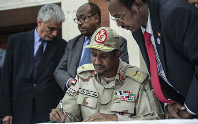 Sur cette photo du 17 juillet 2019, le général Mohammed Hamdan Daglo signe un document de partage du pouvoir entre le mouvement pro-démocratie du Soudan et le conseil militaire au pouvoir à Khartoum, au Soudan. (Photo AP / Mahmoud Hjaj, File)