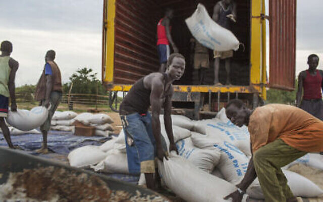 Des employés débarquent des sacs de céréales du programme alimentaire des Nations unies (WFP) à Minkaman, au sud Saoudan, le 26 juin 2014. (Crédit : AP Photo/Matthew Abbott) Des employés débarquent des sacs de céréales du programme alimentaire des Nations unies (WFP) à Minkaman, au sud Saoudan, le 26 juin 2014. (Crédit : AP Photo/Matthew Abbott)