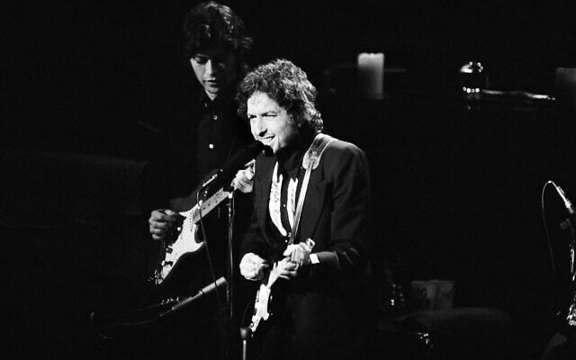 Le chanteur Bob Dylan sur la scène du Madison Square Garden de New York, le 30 janvier 1974, lors de l'une de ses trois apparitions avec The Band à New York. Robbie Robertson, à gauche, accompagne Dylan à la guitare. (Crédit : AP / Ray Stubblebine) Le chanteur Bob Dylan sur la scène du Madison Square Garden de New York, le 30 janvier 1974, lors de l'une de ses trois apparitions avec The Band à New York. Robbie Robertson, à gauche, accompagne Dylan à la guitare. (Crédit : AP / Ray Stubblebine)